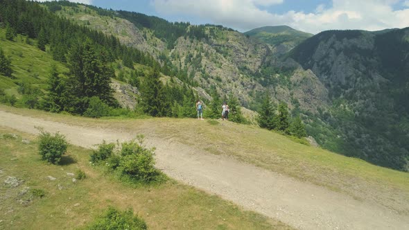 Hikers Taking Pictures at the Edge of a Hill with Beautifull View of the Valley Below