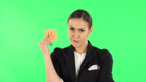 Girl Holding Paper Stick Expressing Awful Mood Then Takes Another Expressing Good Mood. Green Screen