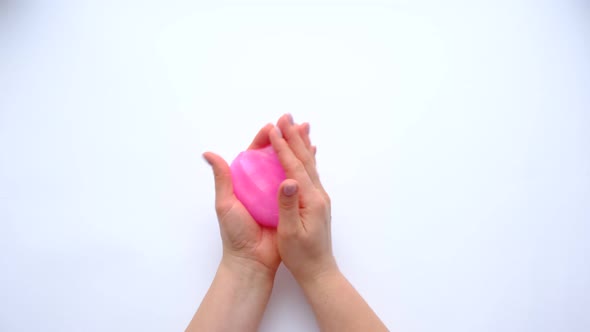 Woman Hands Playing with Pink Slime on White Background