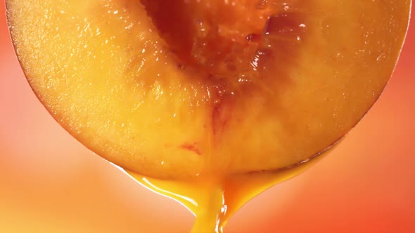 Slow Motion Macro Shot of Flowing Peach Juice From Half Peach