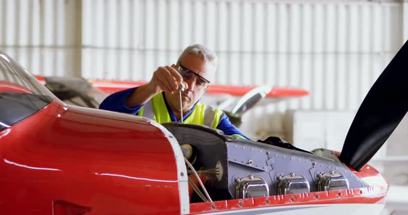 Engineer repairing aircraft in hangar 4k