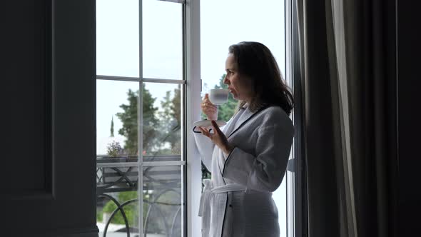 Woman in Bathrobe Drinking Coffee at Hotel Room