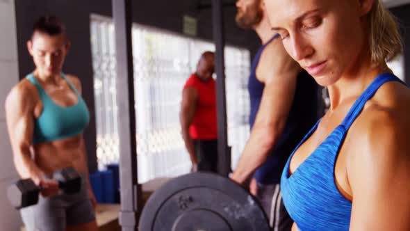 Beautiful fit woman exercising with dumbbell