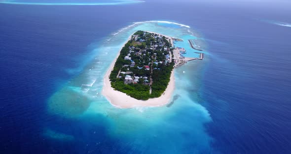 Tropical flying copy space shot of a white sandy paradise beach and aqua blue water background in 4K