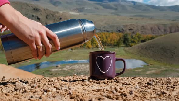 Woman Pouring Tea While Hiking in Altai Mountains