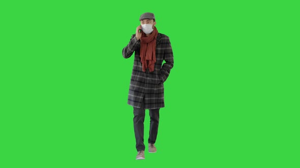 Fashionable Gentleman in Medical Mask Calling on the Phone on a Green Screen, Chroma Key.