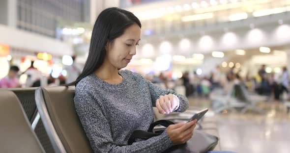 Woman use of cellphone and waiting at Hong Kong airport 