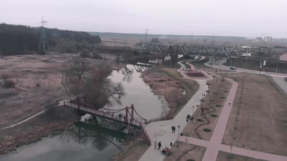 Pedestrian city quay with walking people along river, aerial drone view