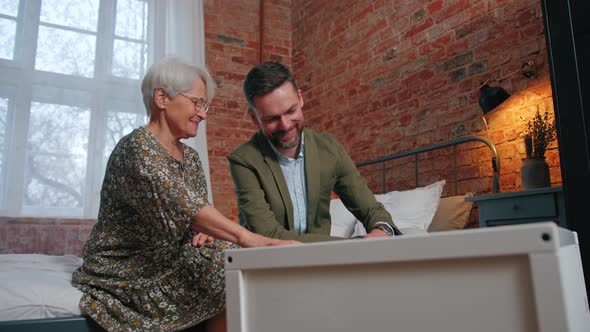 European Relatives Happily Discussing Parenthood and Fatherhood Over a White Crib