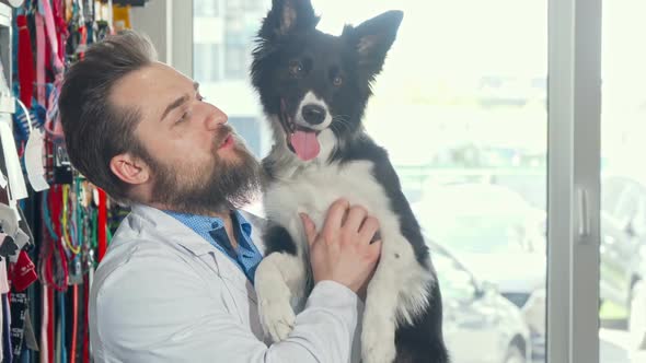 Cheerful Bearded Veterinarian Petting Adorable Dog at His Clinic