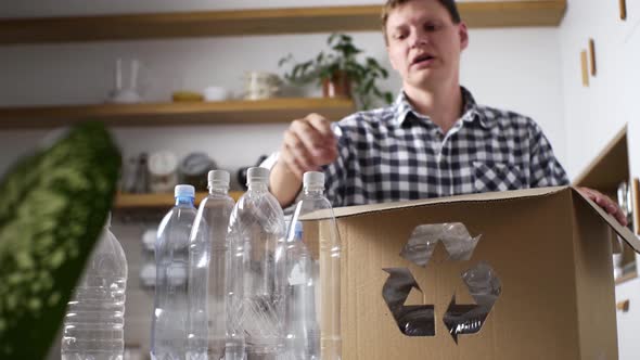 A White Man Stacks Plastic Bottles For Recycling Recycling Reuse, Plastic Garbage Sorting Into Boxes