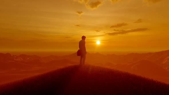 Young Student Watching the Sunset on the Top of the Mountain