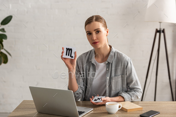 zodiac sign at table with laptop and coffee