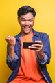 Excited Asian young man looking at mobile phone celebrating victory   - PhotoDune Item for Sale