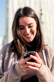 woman smiling happy while texting on her phone - PhotoDune Item for Sale