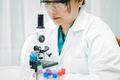 Asian scientist biochemist working research with a microscope in laboratory.  - PhotoDune Item for Sale