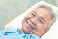 Asian elderly woman patient smile bright face with strong health while lying on bed in hospital. - PhotoDune Item for Sale