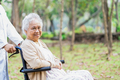 Doctor help and care Asian elderly woman patient sitting on wheelchair at park in nursing hospital. - PhotoDune Item for Sale
