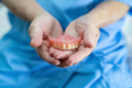 Asian senior woman patient holding to use denture in nursing hospital. - PhotoDune Item for Sale