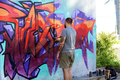 A street artist paints colored graffiti on the wall of a public space. - PhotoDune Item for Sale