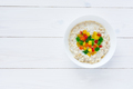 Oatmeal with candied fruits in a white plate on a white wooden background. - PhotoDune Item for Sale
