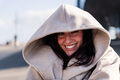 joyful young woman hiding under her coat hood - PhotoDune Item for Sale
