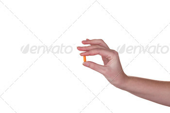 Hand holding an orange capsule isolated on white background