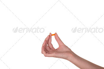 Hand holding an orange capsule isolated on white background