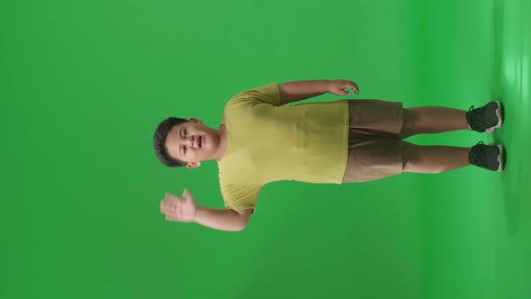 Full Body Of Happy Asian Little Boy Waving Hand And Say Bye Bye While Standing On Green Screen