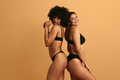 Joyful young diverse female friends smiling at camera in studio - PhotoDune Item for Sale