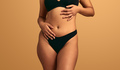 Crop unrecognizable woman with curvy body touching belly - PhotoDune Item for Sale