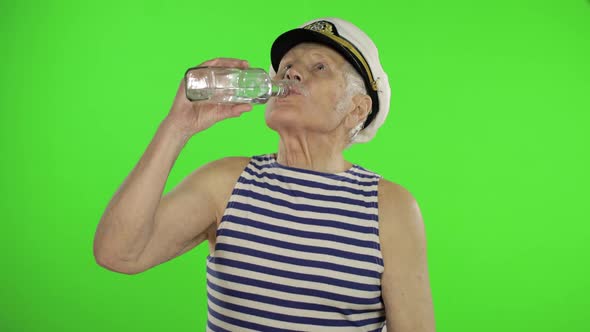 Elderly Sailor Man with Mustache Drinks Vodka. Old Sailorman on Chroma Key