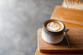Beautiful ceramic cup of cappuccino with latte art on wooden background. - PhotoDune Item for Sale