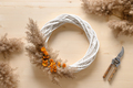 Woman making wreath with orange flowers and dry natural materials. - PhotoDune Item for Sale