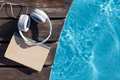 Book and headphones near swimming pool - PhotoDune Item for Sale