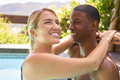 Loving Smiling Multi-Racial Couple On Holiday Hugging In Swimming Pool - PhotoDune Item for Sale