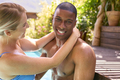 Loving Smiling Multi-Racial Couple On Holiday Hugging In Swimming Pool - PhotoDune Item for Sale