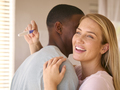 Hugging Multi-Racial Couple In Bedroom At Home Celebrating Positive Pregnancy Test Result - PhotoDune Item for Sale