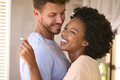 Hugging Multi-Racial Couple In Bedroom At Home Celebrating Positive Pregnancy Test Result - PhotoDune Item for Sale
