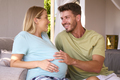 Couple With Pregnant Woman In Bedroom At Home With Man Feeling Baby Kicking - PhotoDune Item for Sale