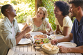 Group Of Smiling Multi-Cultural Friends Outdoors At Home Eating Meal And Drinking Wine Together - PhotoDune Item for Sale