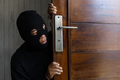 Thief robber spying and hiding behind a wooden door - PhotoDune Item for Sale