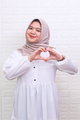 Asian muslim woman smiling confident showing hands sign of love  - PhotoDune Item for Sale