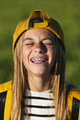 Portrait of beautiful young blonde girl in a yellow cap and a bracket on her teeth. - PhotoDune Item for Sale