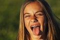 Portrait of a beautiful young blonde woman showing her tongue and a bracket in her teeth. - PhotoDune Item for Sale