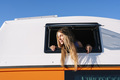 The happy girl sticks her head out of the van window on a wonderful day at camp. Van life concept. - PhotoDune Item for Sale