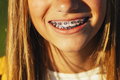 Portrait of beautiful young blonde girl in a yellow cap and a bracket on her teeth. - PhotoDune Item for Sale