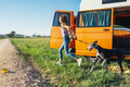 The happy girl with the dog has fun on a wonderful camping day. Van life concept. - PhotoDune Item for Sale