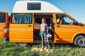 The happy girl with the dog has fun on a wonderful camping day. Van life concept. - PhotoDune Item for Sale