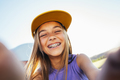 Beautiful teen girl taking selfies in a yellow cap and bracket on her teeth. - PhotoDune Item for Sale
